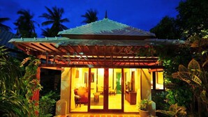 A traditional-style building with a tiled roof, wooden pergola, and a well-lit interior. - Bhumlapa Garden Resort (Koh Samui)