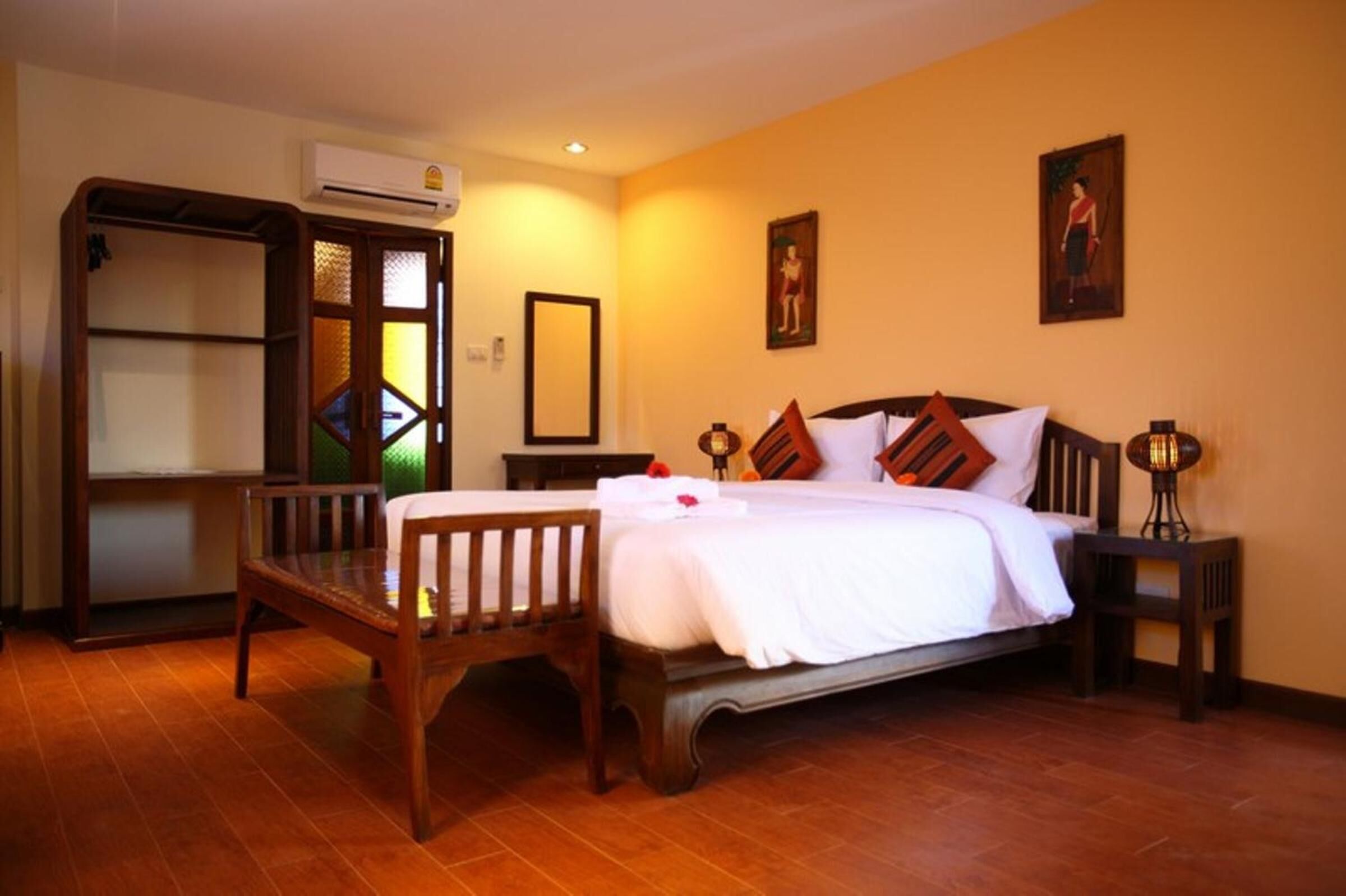 A neatly arranged bedroom with a bed, a wooden chair, a nightstand, and a shelf unit.
