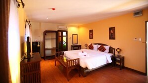 Una habitación de hotel con cama, mesitas de noche, escritorio y armario.