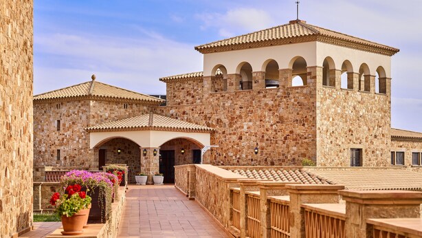 A stone building with arched doorways and a tiled roof. - Hapimag Resort Mas Nou (Castell-Platja d'Aro)
