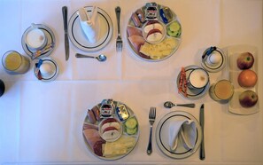 A breakfast setup with plates of food, utensils, and glasses. - Hotel Engelbert (Düsseldorf)