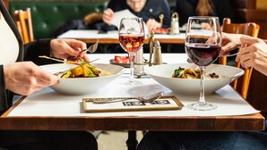 A dining table with two bowls of food, wine glasses, and cutlery. - Gerlóczy Boutique Hotel (Budapest)