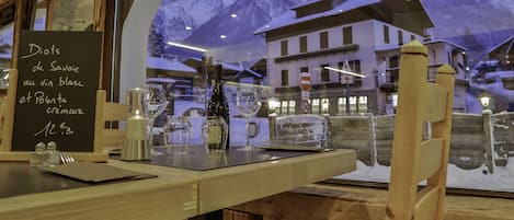 Un restaurante con vistas a montañas nevadas a través de un amplio ventanal.