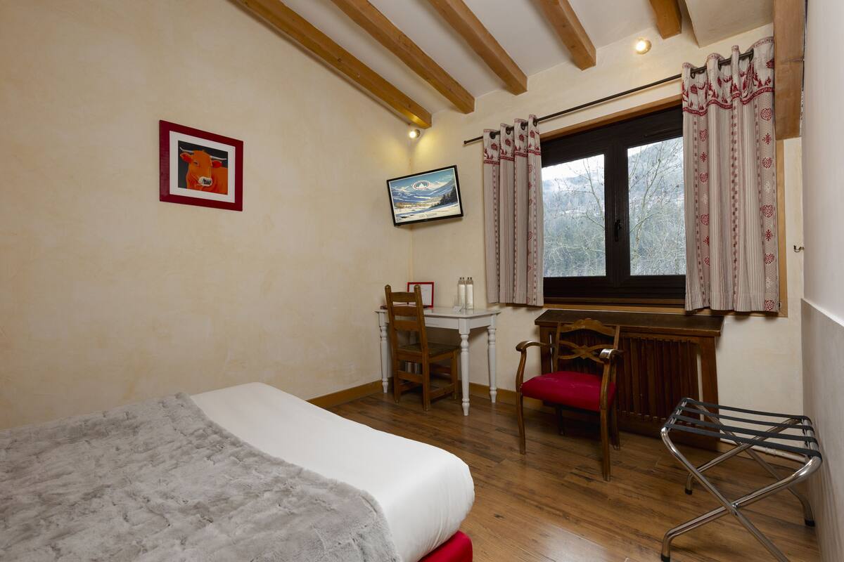 Ein Schlafzimmer mit einem Bett, einem Schreibtisch und einem Stuhl.