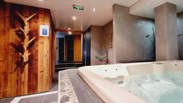 Relax in a spa room with a large hot tub and unique geometric design.