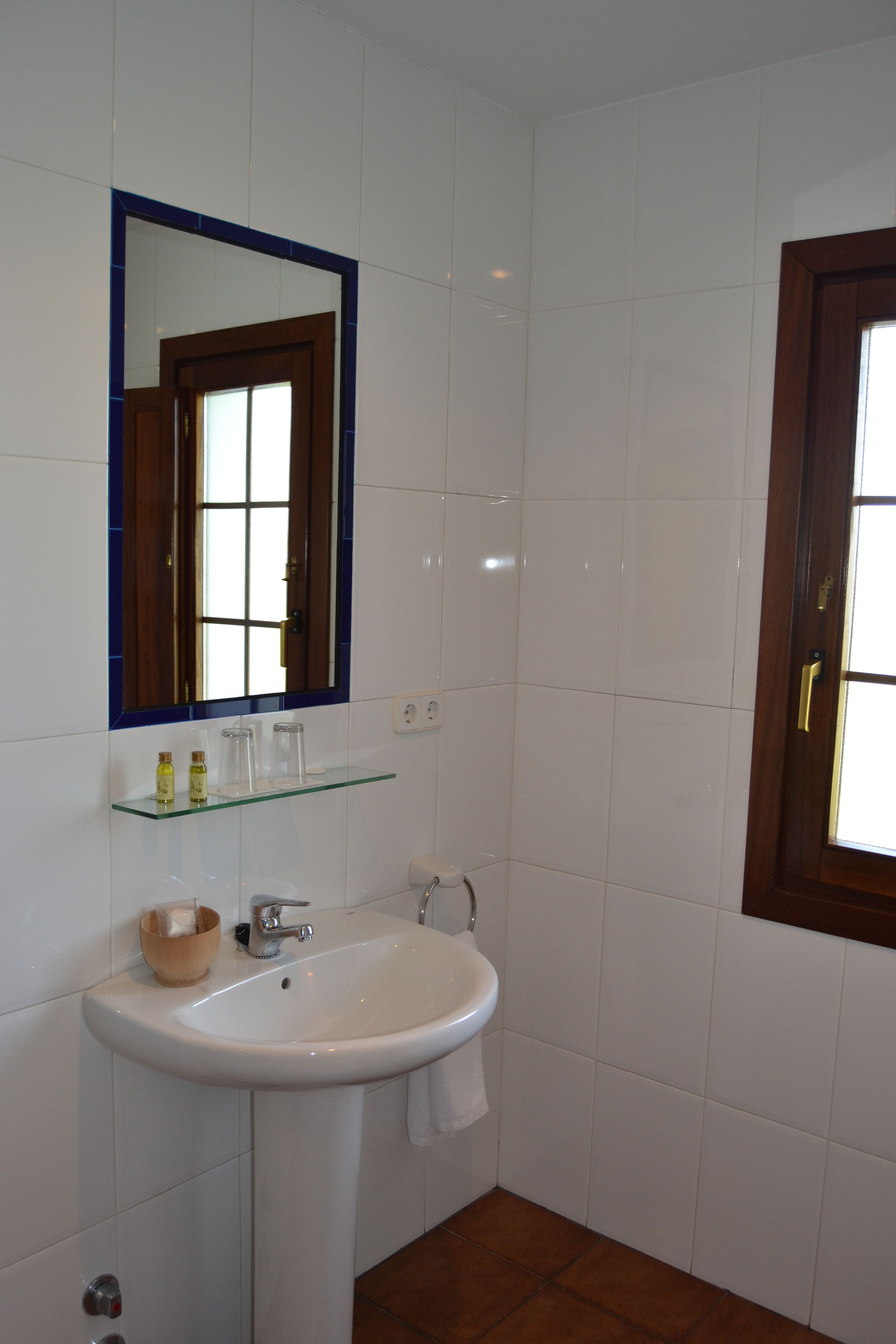 A bathroom with a white sink, a mirror, and a wooden door.