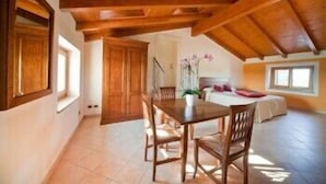 A cozy attic bedroom with a wooden ceiling, a bed, and a window. - Corte Pontigliardo (Lazise)