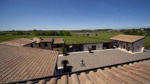 A courtyard with tiled roofs, a central open space, and surrounding buildings. - Corte Pontigliardo (Lazise)