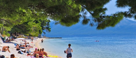 Una playa cerca, sillas reclinables de playa, sombrillas