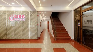 A modern hotel lobby with a marble reception desk, a staircase, and a glass door entrance. - Lira Pacific Aparthotel (Constanta)