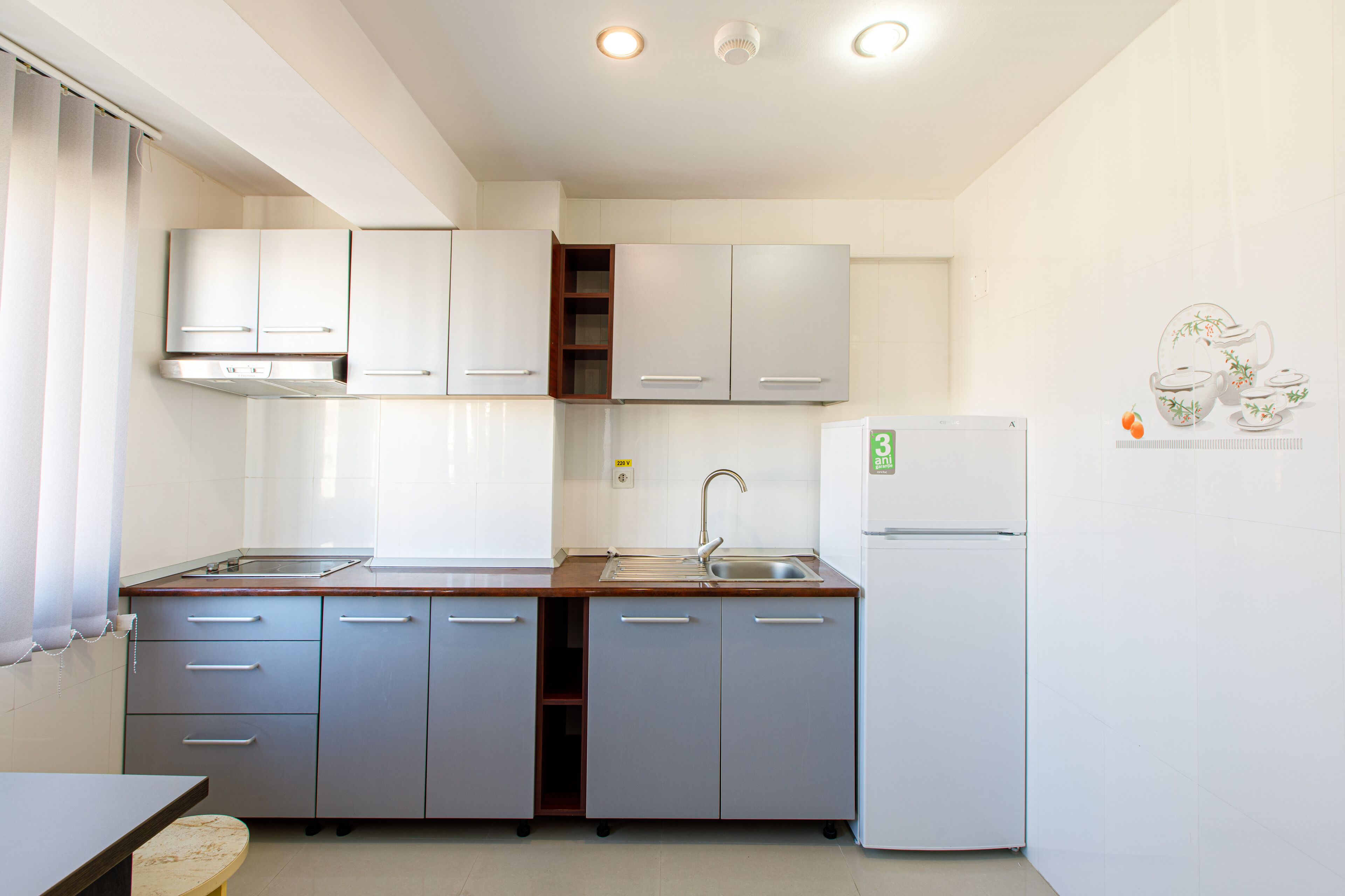 A compact kitchen with a sink, stove, and refrigerator.