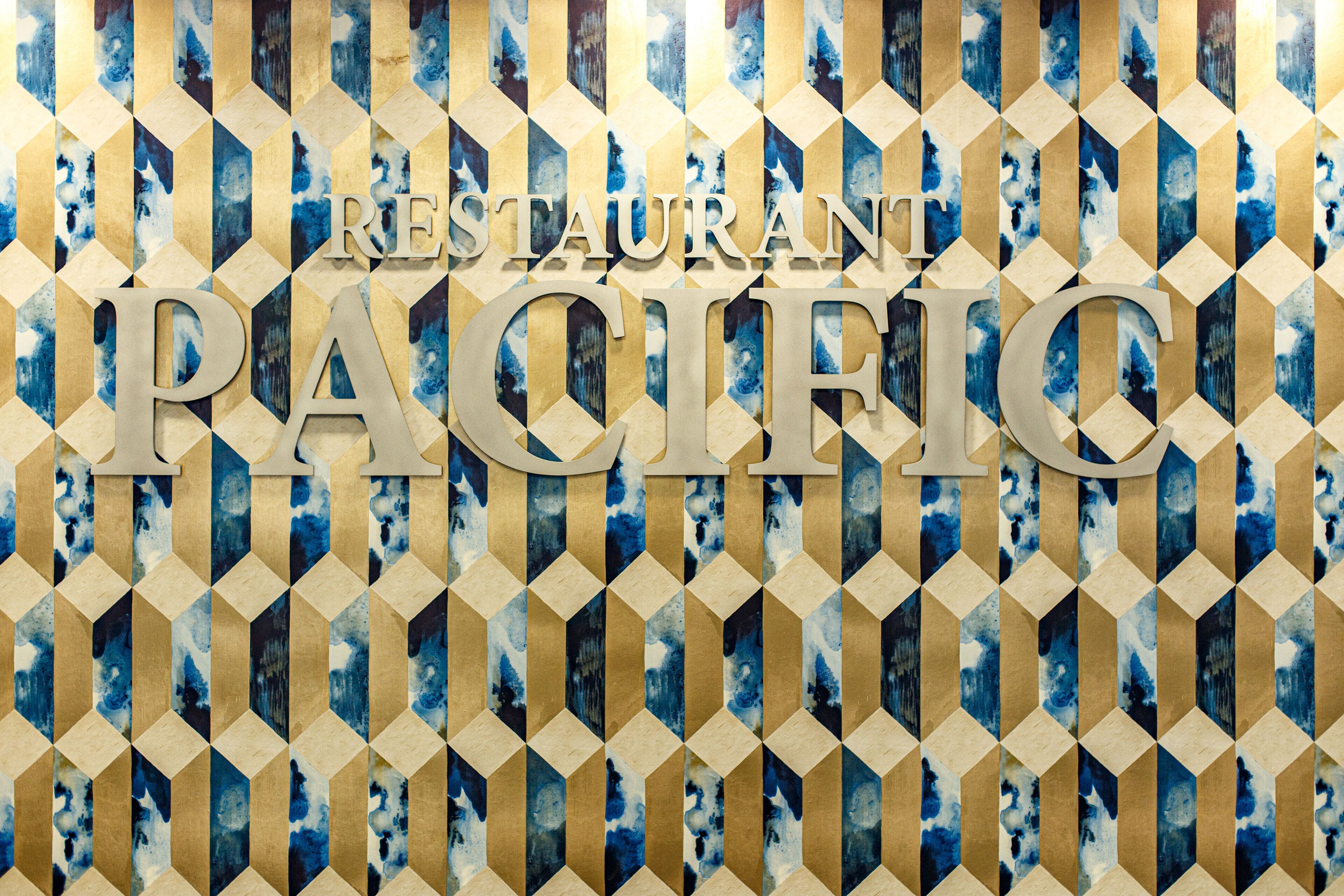 A geometric patterned wall with the text "RESTAURANT PACIFIC" prominently displayed.