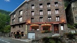 A stone building with multiple windows and a restaurant on the ground floor. - Hotel Montane (Arinsal)