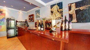 A bar area with a wooden counter, wine bottles, and a coffee machine. - Hotel Montane (Arinsal)