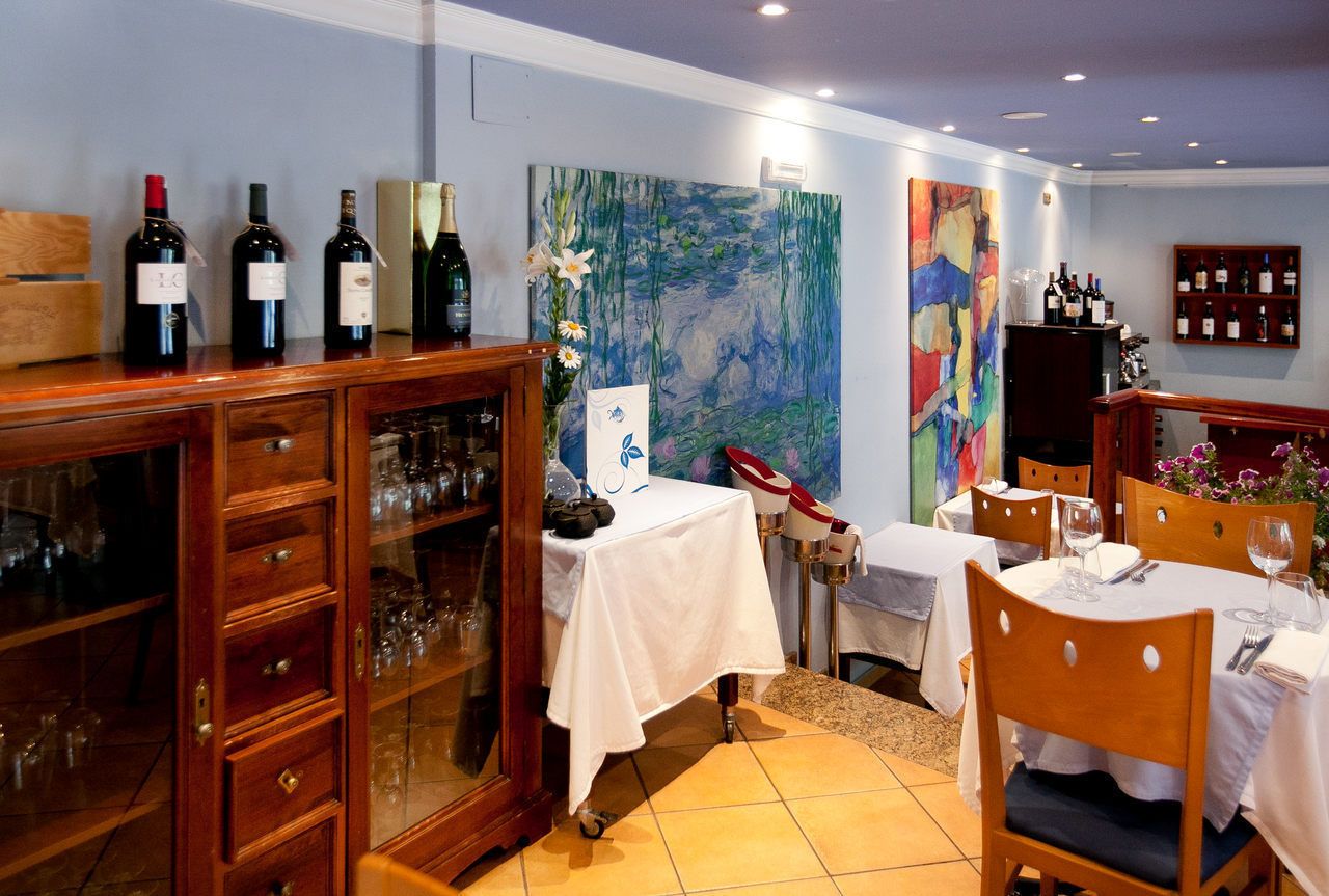 A dining area with wooden cabinets, a white table, and a painting on the wall.