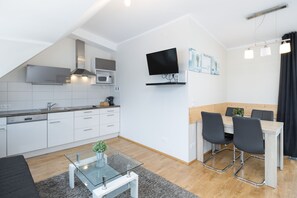 Appartement Deluxe | Coin séjour | Télévision à écran plat de 32 pouces avec chaînes par câble, télévision