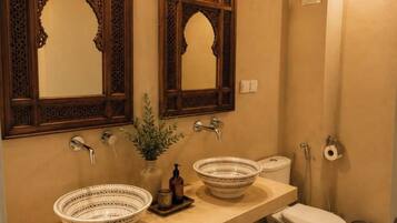 A bathroom with two sinks, a toilet, and a shower.