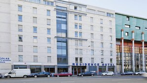 A multi-story building with a sign for 'RESIDENCE HOTEL' and a 'Humans' store on the ground floor. - Séjours & Affaires Lyon Saint-Nicolas (Lyon)