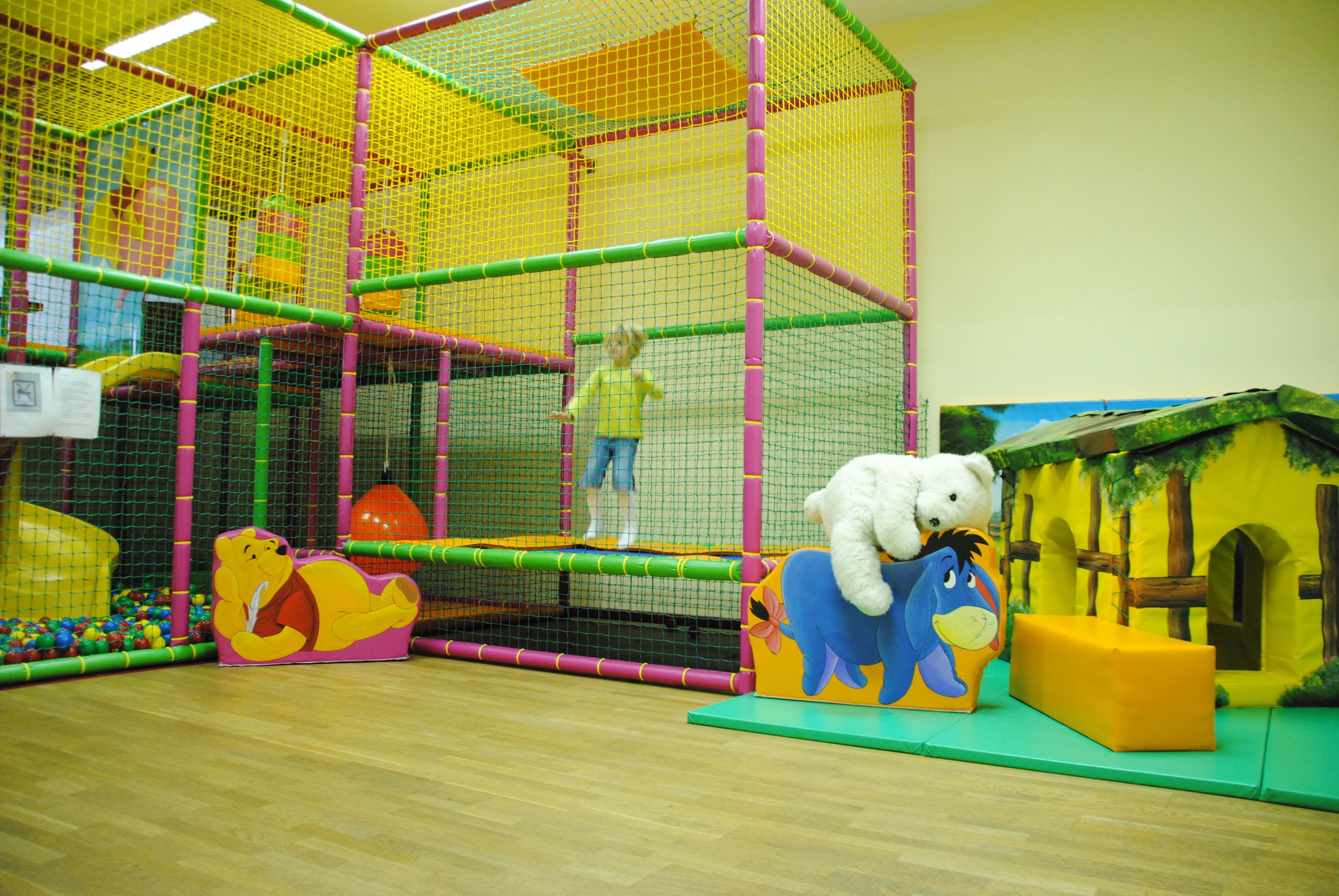 A play area with a net enclosure, a ball pit, and a slide.