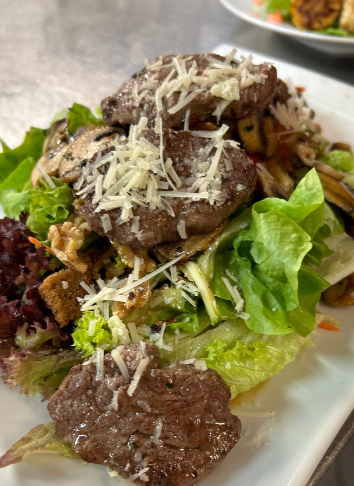 A plate of food with meatballs, cheese, and salad.