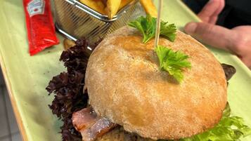 A sandwich with lettuce, a bun, and a side of fries on a plate.
