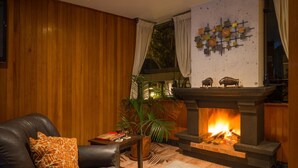Una sala de estar acogedora con chimenea, sofá de cuero y un adorno en la pared.