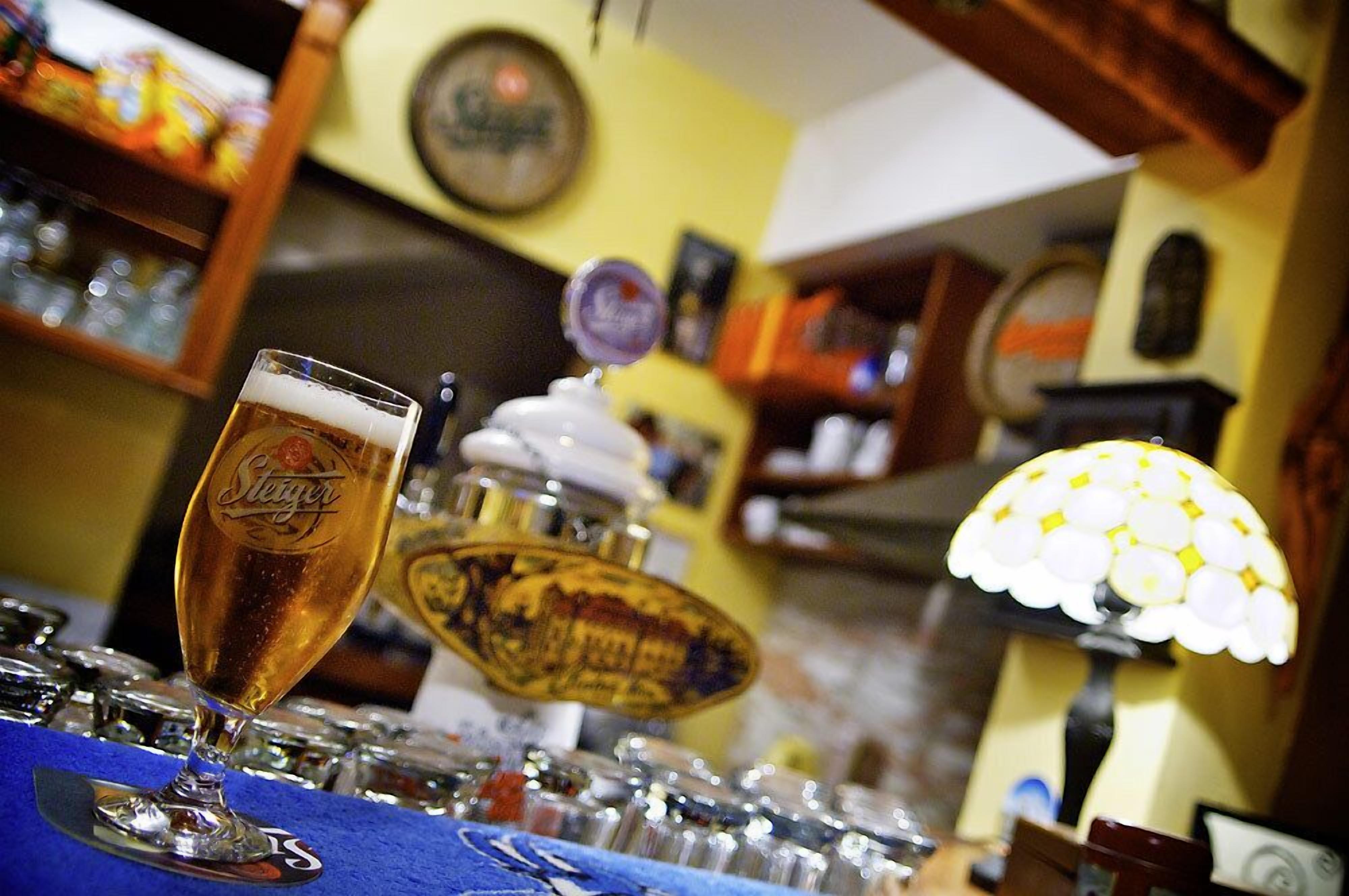 A bar area with a glass of beer, a beer tap, and a decorative lamp.