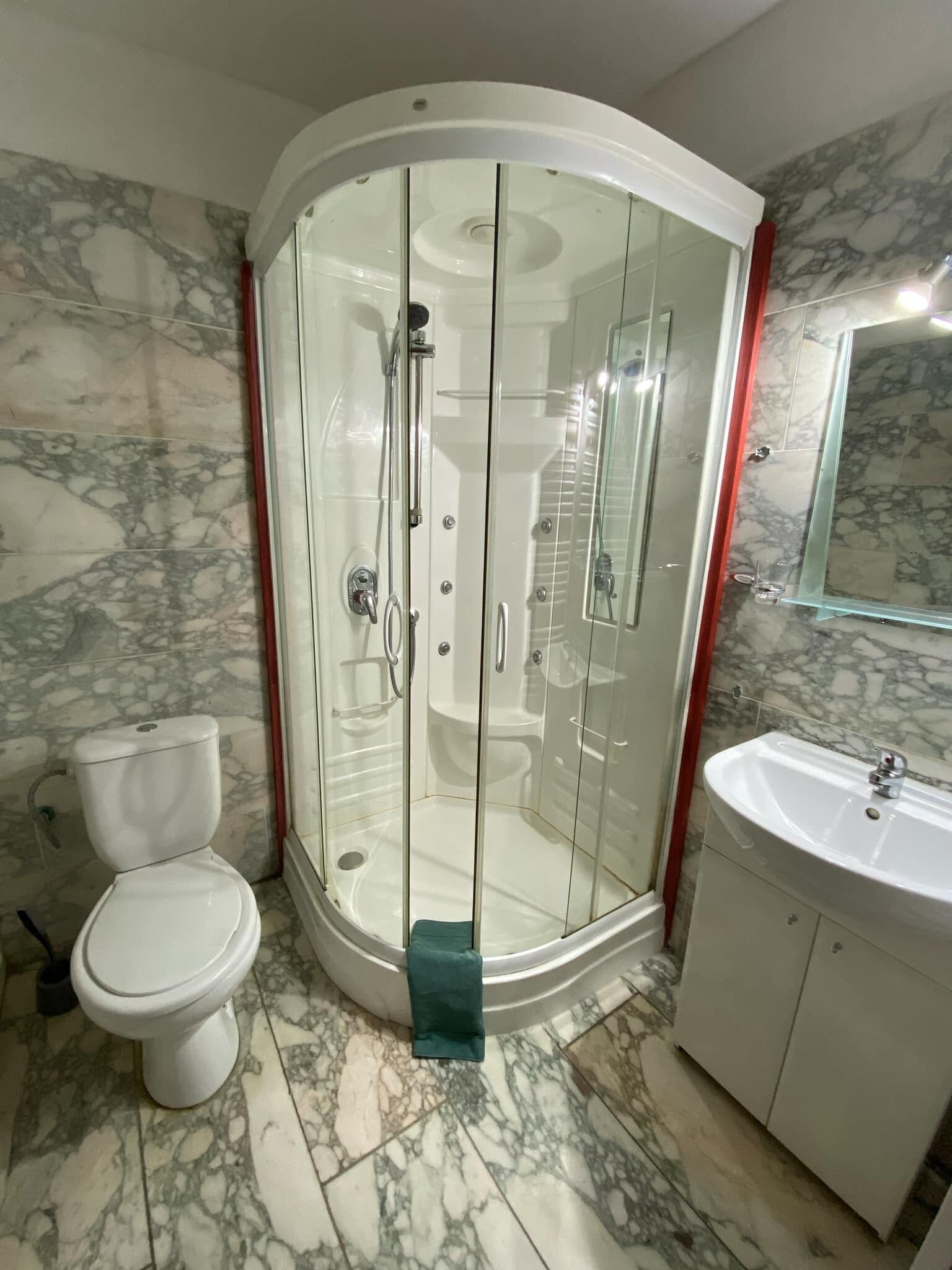 Ein Badezimmer mit Duschkabine, Toilette und Waschbecken.