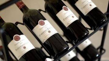 Une étagère remplie de bouteilles de vin, toutes étiquetées, probablement située dans une cave à vin ou dans un espace de stockage.