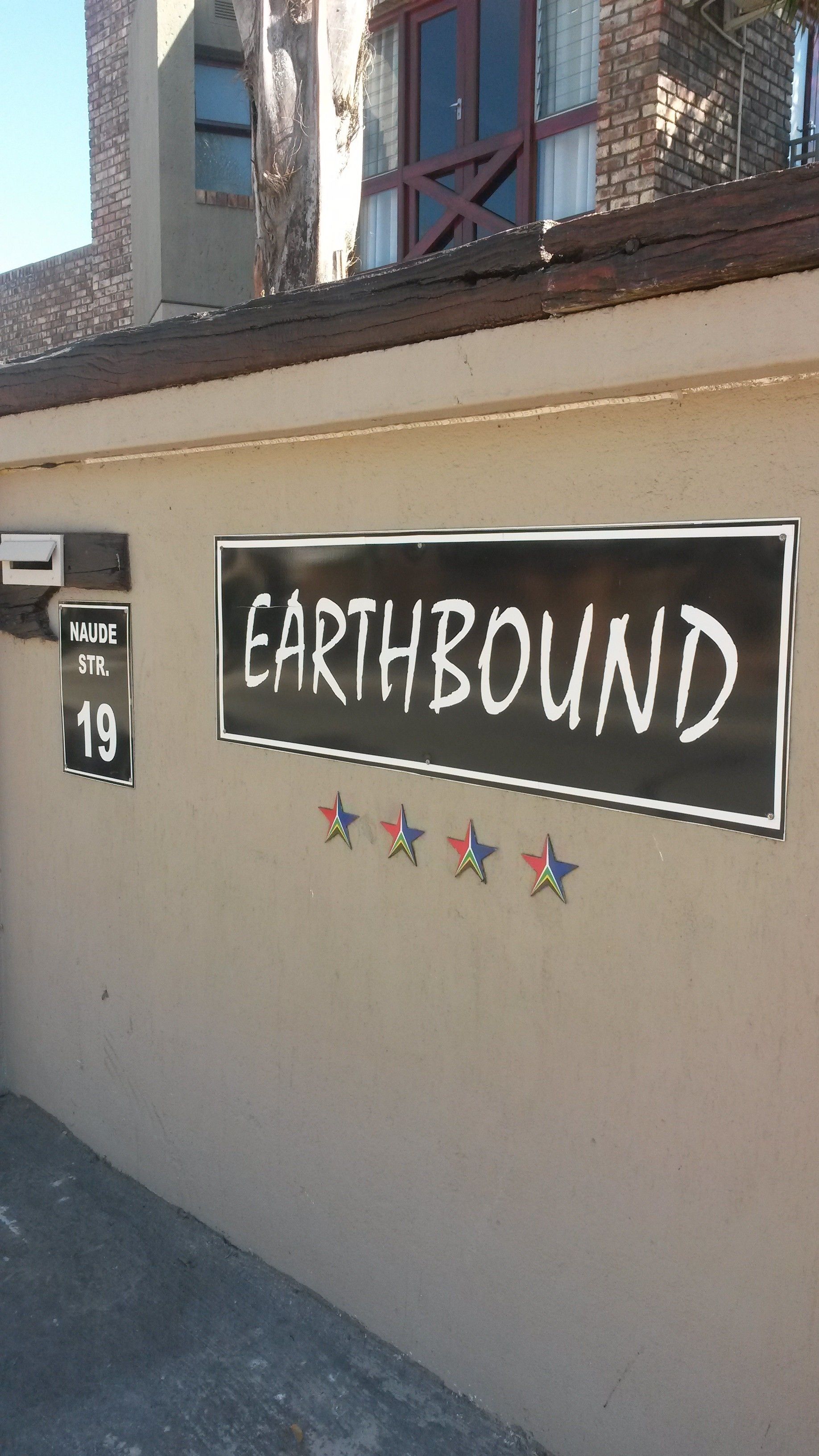A wall with the text "EARTHBOUND" and a street sign "NAUDE STR. 19".