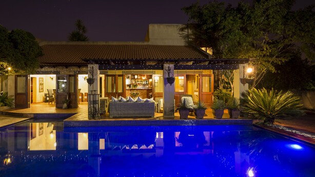 A poolside area with a bar, outdoor seating, and a covered patio.