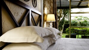 A bed with white linens, a wall clock, and a lamp.