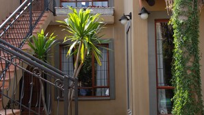 A multi-level building with a staircase, a balcony, and a window with a view.