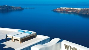 A white infinity pool with lounge chairs and a sign reading "White". - White Santorini (Santorini)