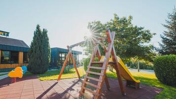 Children can play on the slide and climb the ladder in this outdoor playground area.