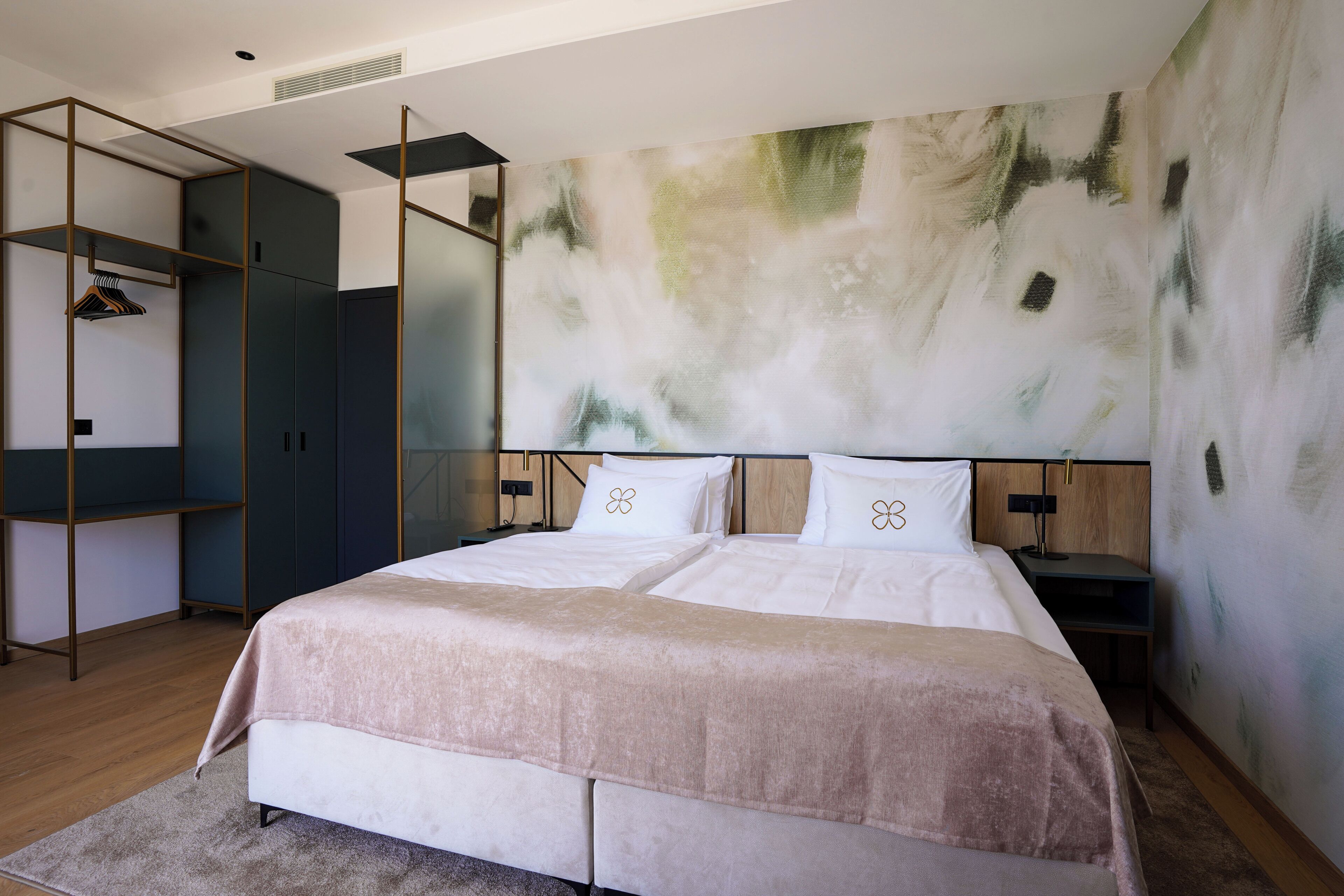 Un dormitorio moderno con una cama grande, un armario y un cuadro abstracto único en la pared.