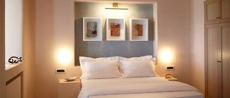 Un dormitorio con cama, mesitas de noche y una obra de arte en la pared.