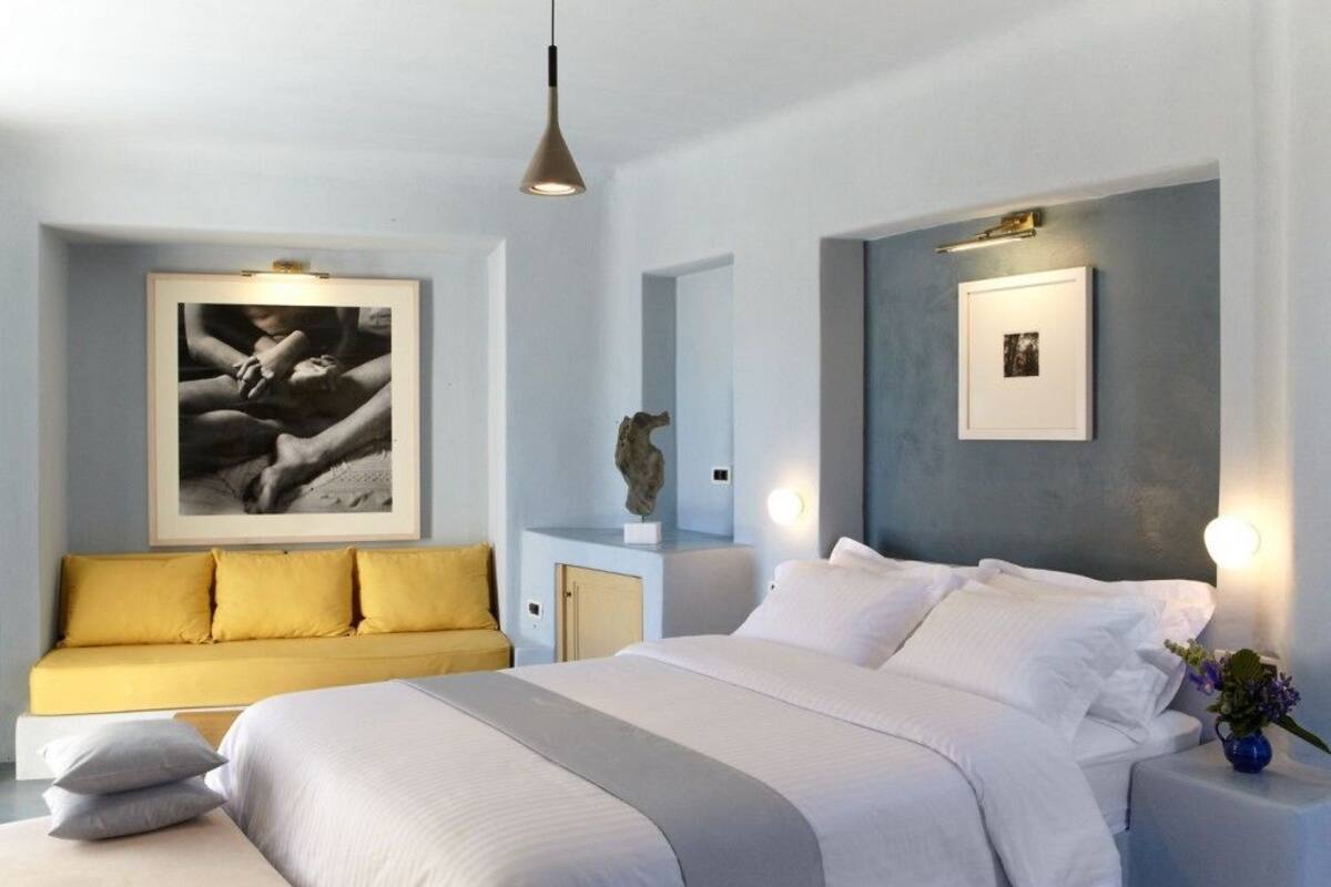 Ein modernes Schlafzimmer mit einem großen Bett, einer Couch und Bildern an den Wänden.