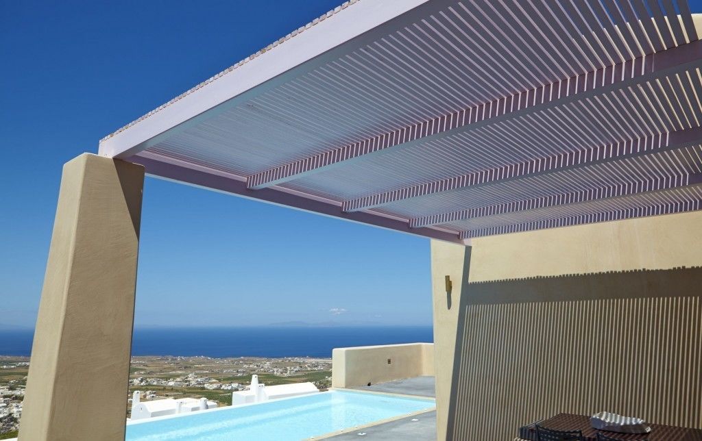 Een zwembadterras met uitzicht op zee en een pergola.