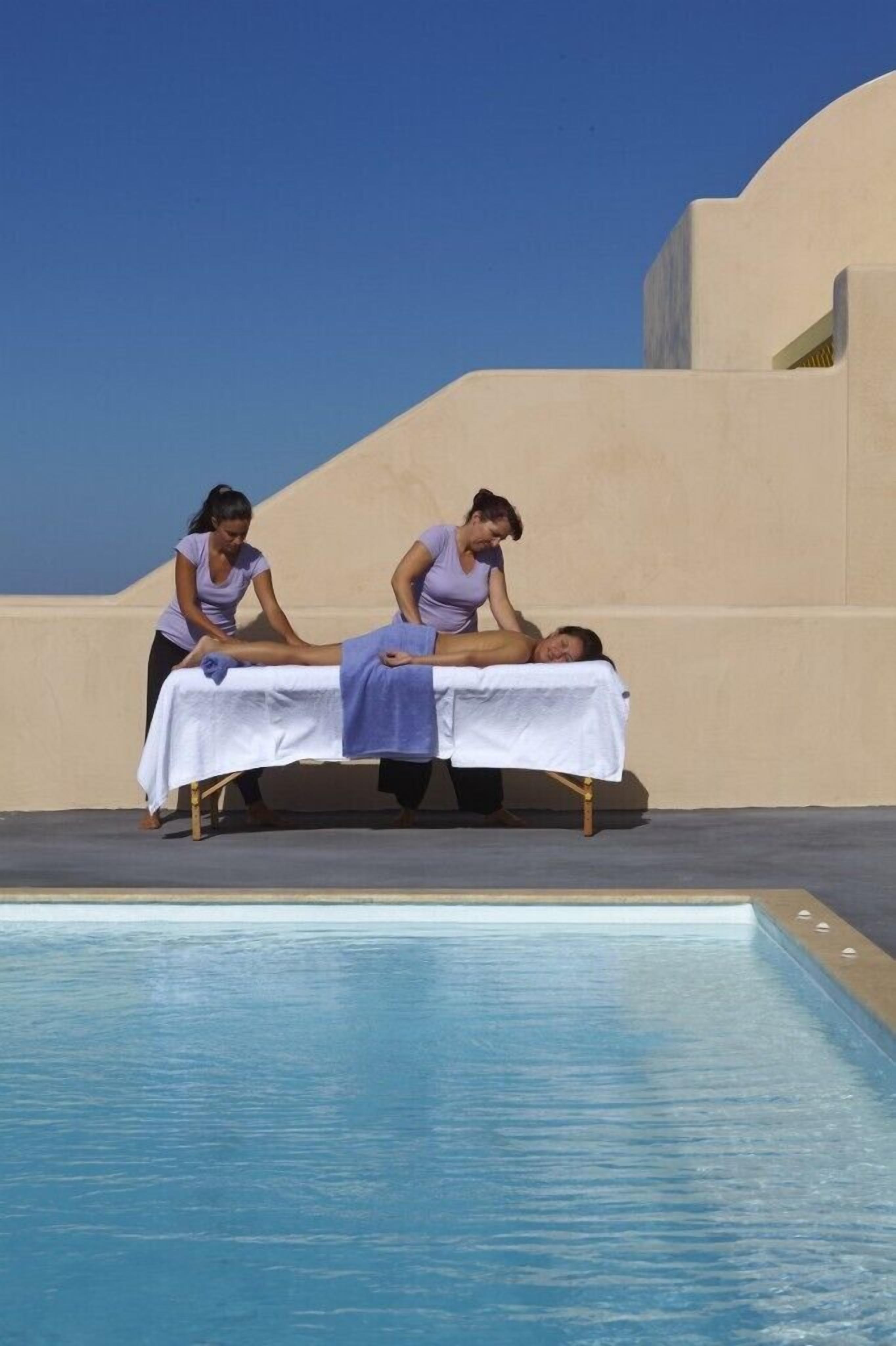 Sesión de terapia de masajes junto a una piscina bajo un cielo despejado.