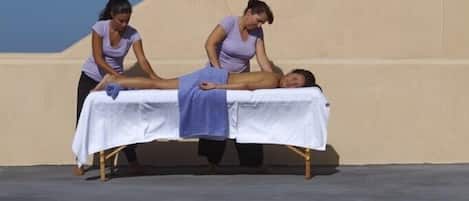 Sesión de terapia de masajes junto a una piscina bajo un cielo despejado.