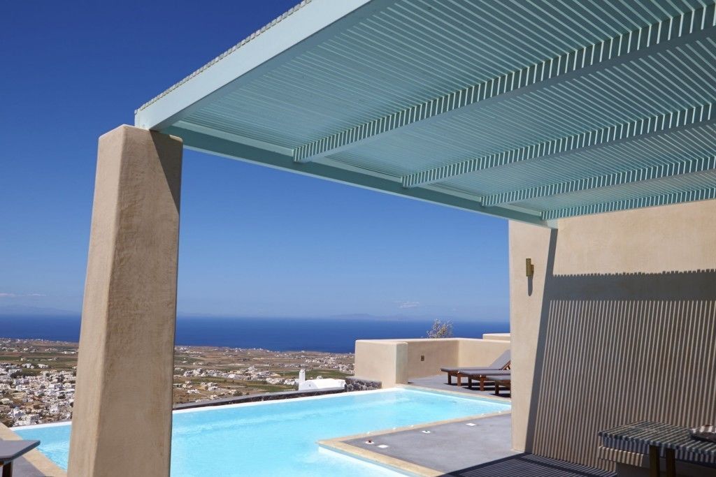A rooftop pool with a clear view of the sea and town in the background.