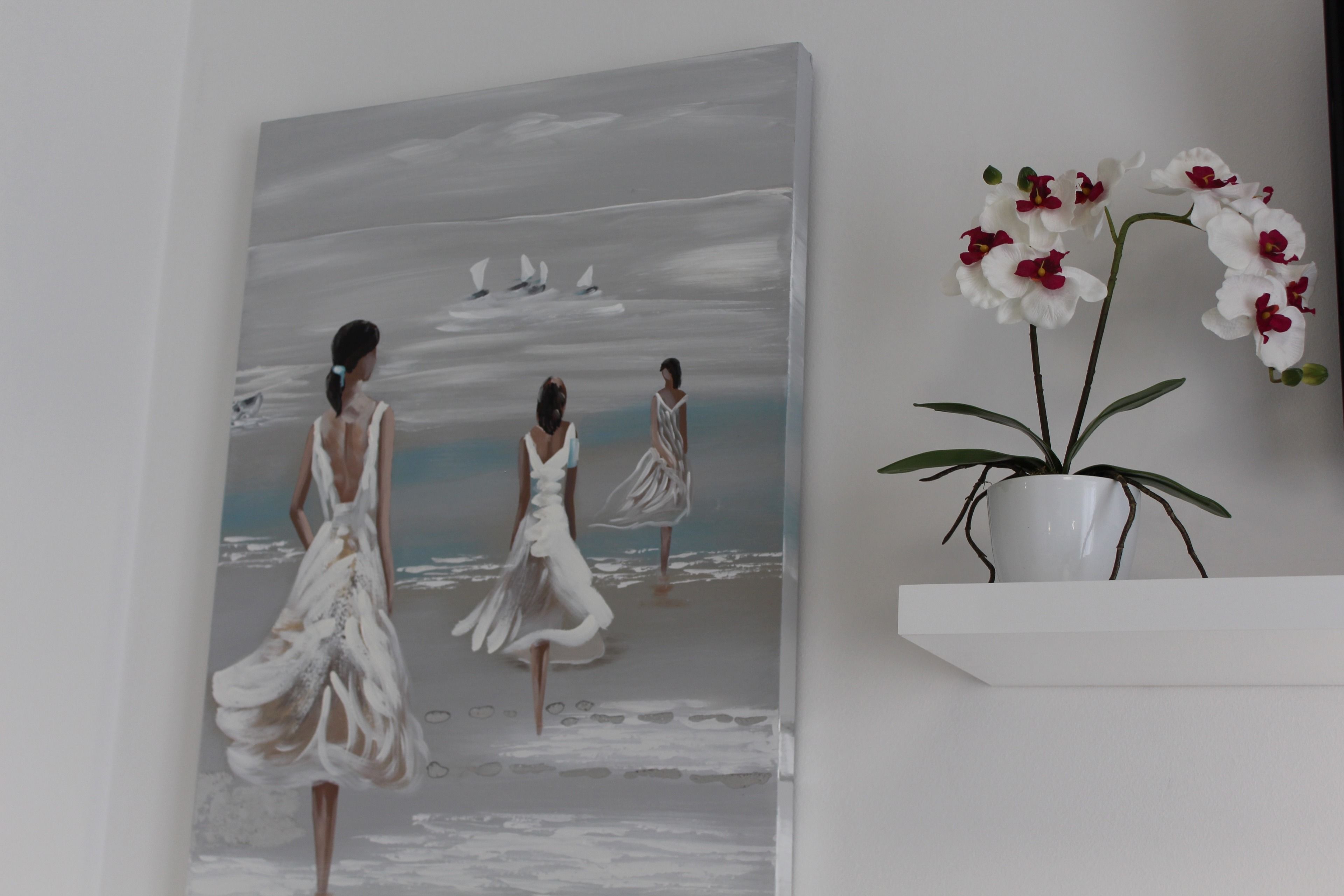 Een schilderij van drie vrouwen in witte jurken op een strand, met zeilboten.
