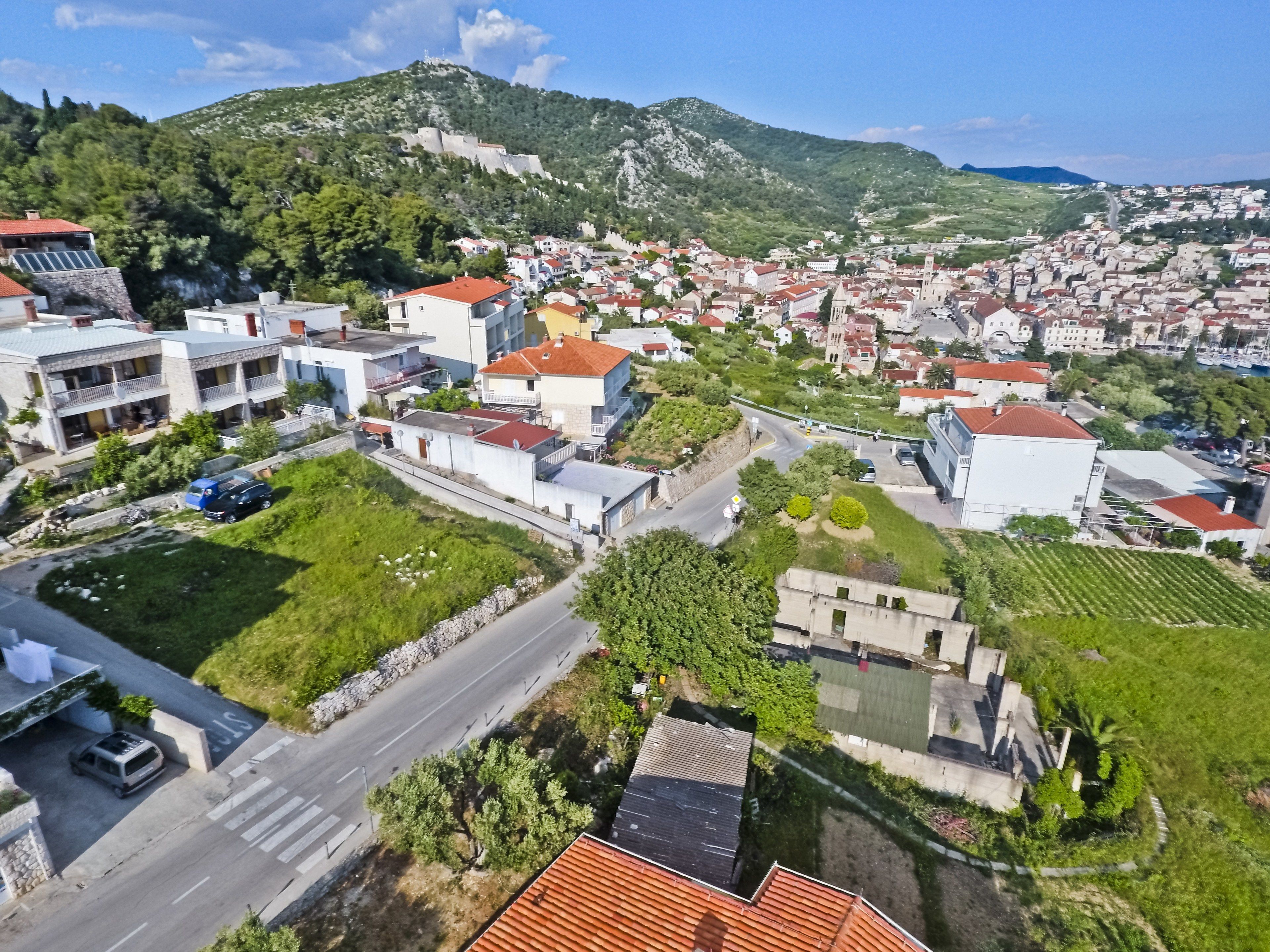 Una zona residencial con casas, una carretera y una colina con una fortaleza.