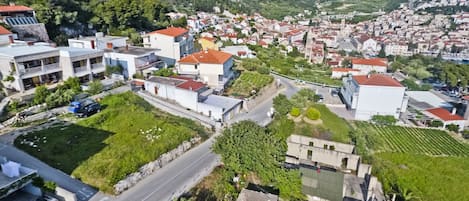 Una zona residencial con casas, una carretera y una colina con una fortaleza.
