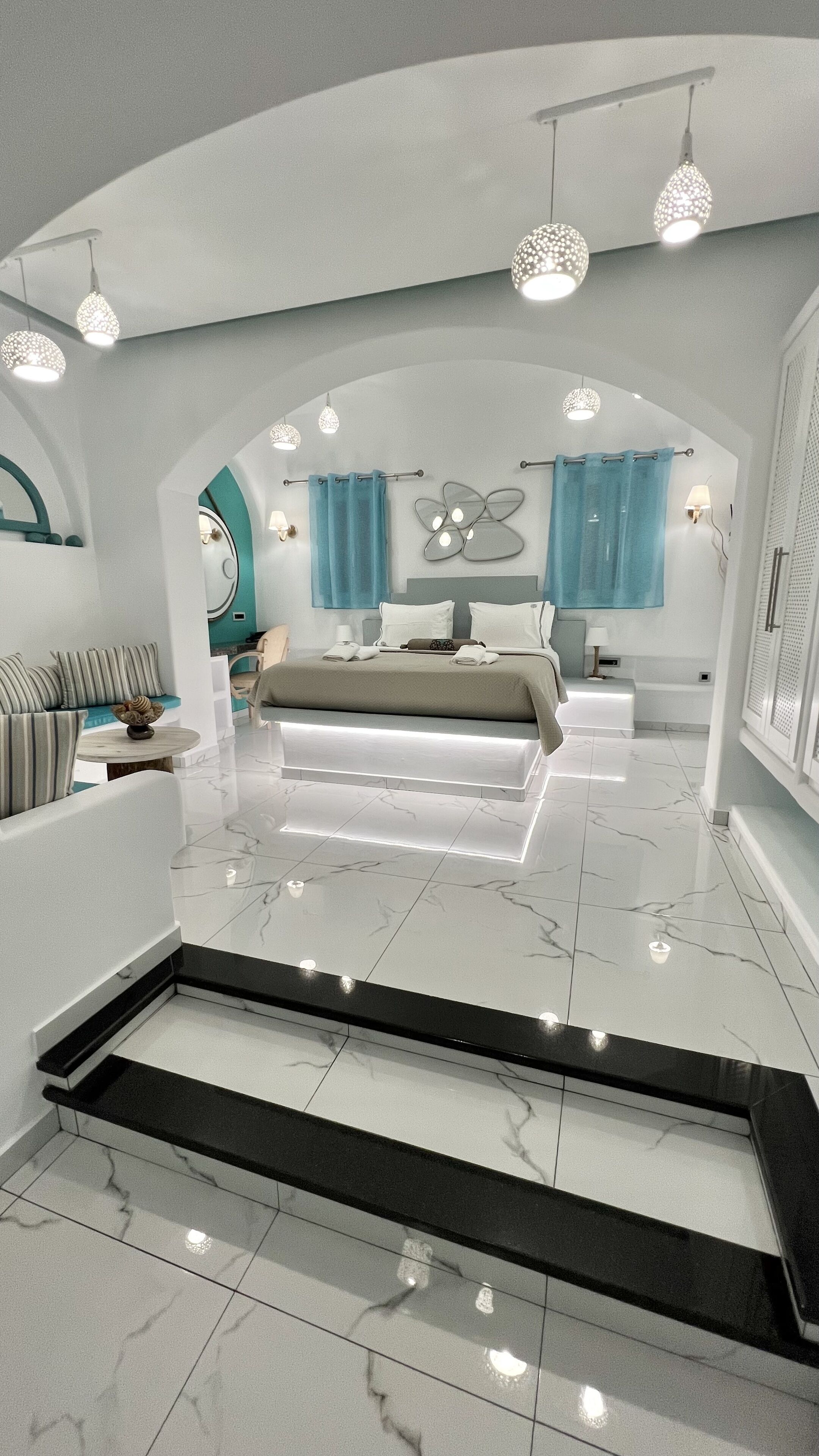 Un dormitorio moderno con una cama grande, un tocador y una zona de estar.