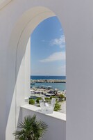 Un balcón con vista a un puerto deportivo y al mar.