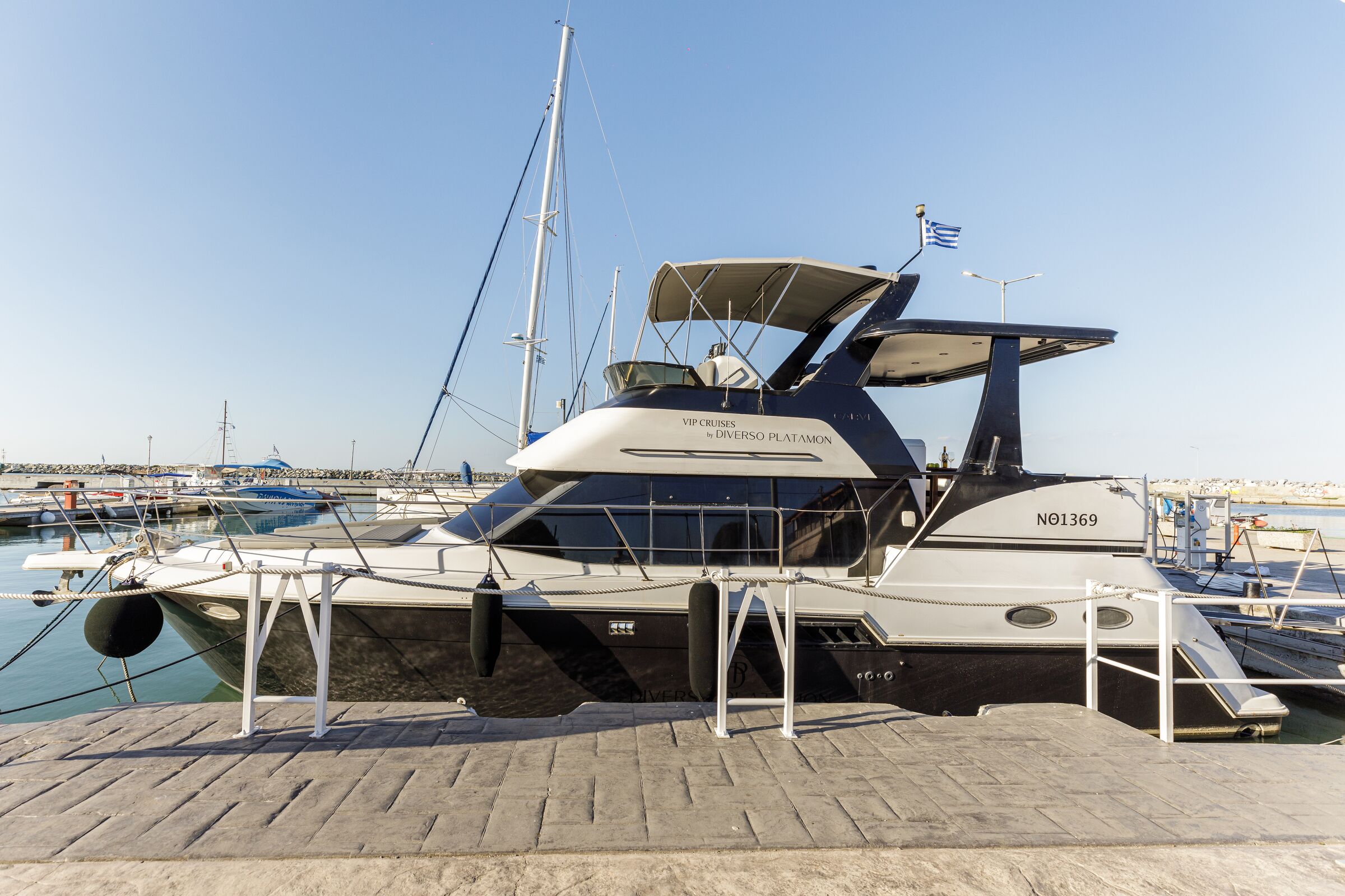 A yacht docked at a marina with a clear sky.