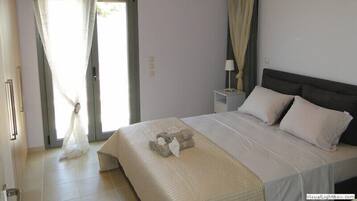 A bedroom with a bed, curtains, a nightstand, and a lamp.