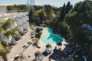 A resort with a swimming pool, lounge chairs, and a wooden deck. - Hôtel Le Quetzal (La Grande-Motte)